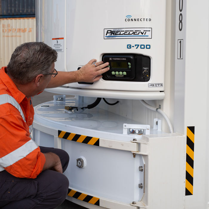 A SCF staff member operates a reefer container motor.